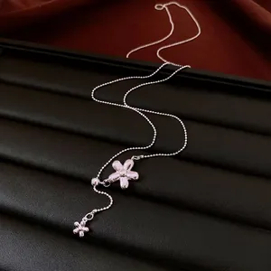 Minimalist silver flower tassel necklace with delicate bead chain and floral pendant.