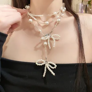 Nahaufnahme einer eleganten mehrlagigen Perlenkette mit schicken Schleifenanhängern