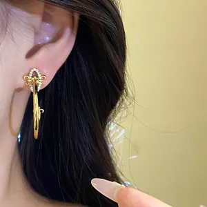 Detailed close-up of elegant gold Fleur-de-lis C-shape stud earring with sparkling zircons.