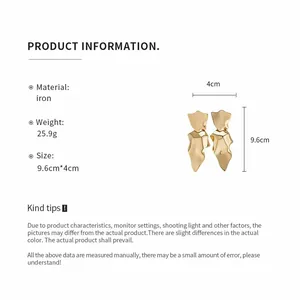 Detail view of irregular gold metal dangle earrings with size and material specifications