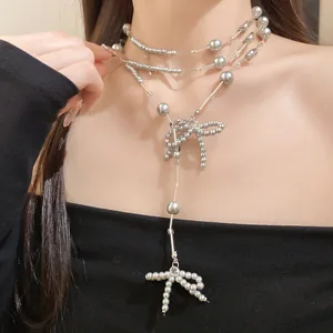 Detailansicht einer mehrlagigen grauen Perlenkette mit eleganten Schleifen aus Perlen.