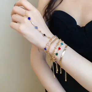 Set of 5 delicate gold-tone bracelets featuring crystals, snake chain and cross charms