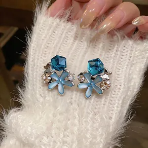 Exquisite blue starfish earrings with crystal rhinestones on white fuzzy background