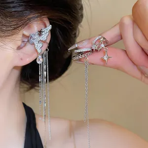 Close-up of elegant silver-tone ear cuff with long sparkling tassel chains and zircons.