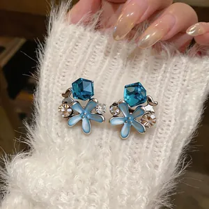 Detailed view of blue starfish stud earrings with sparkling rhinestones and enamel