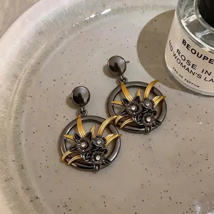Orecchini vintage in metallo scuro a fiori traforati con strass brillanti da donna