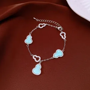 Close-up of elegant gourd charm bracelet with blue inlay and sparkling pavé zircons