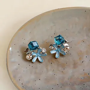 Detailed view of silver-tone starfish earrings with blue enamel and crystal accents
