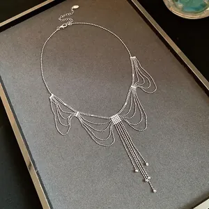 Élégant collier à franges argentées avec un design en dentelle délicate sur un plateau