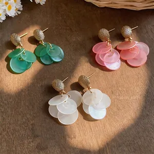 Elegant multi-colored resin disc fringe stud earrings with textured gold accents.