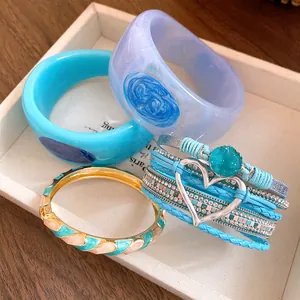 Detailed view of stylish resin bangles and a blue multi-layer heart charm bracelet