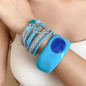 Close-up of a blue resin bangle with drip oil effect and multi-layer charm bracelets.