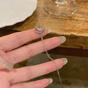 Close-up of elegant silver double-layer zircon ear cuff with long chain tassel