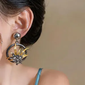 Primo piano di orecchini a lobo vintage a fiore cavo con dettagli in strass