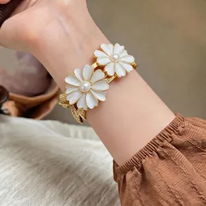 Elegant forest style daisy bangle featuring white enamel flowers and central pearl accents