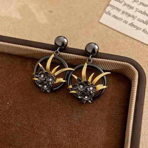 Dettaglio di eleganti orecchini a fiore vintage neri e oro con strass fini e scintillanti