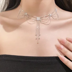 Détail du collier à franges argentées avec un design élégant type dentelle drapée