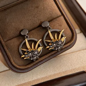 Orecchini circolari vintage in metallo scuro con dettagli floreali dorati in portagioie