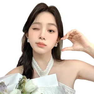 Elegant floral basket pearl earrings with sparkling cubic zirconia shown on a model