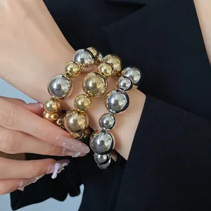 Set of three stylish gold and silver irregular metallic beaded bracelets for women