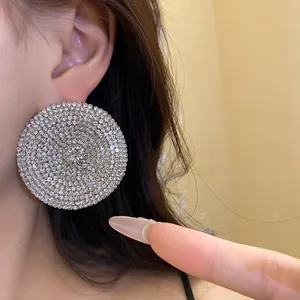 Primer plano de pendientes circulares con incrustaciones de strass brillantes