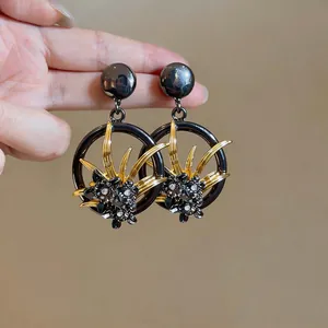 Orecchini vintage circolari con design a fiori cavi e brillanti dettagli in strass