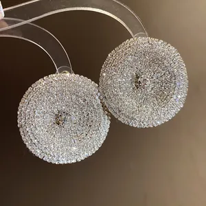 Primer plano de pendientes redondos con micro pavé de cristales brillantes