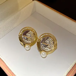 Gros plan détaillé sur des boucles d'oreilles vintage tête de cheval avec zircons et perle