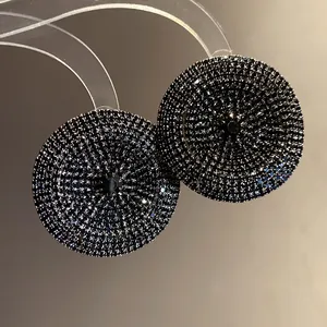 Primer plano de elegantes pendientes de botón redondos con pavé de strass oscuros