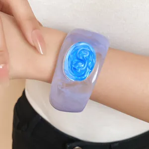 Detailed view of wide purple translucent resin bangle featuring a blue swirl enamel center