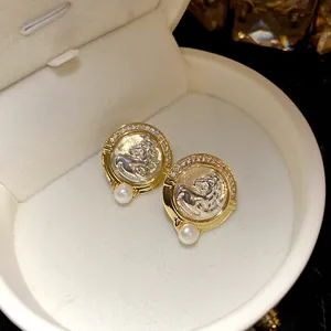 Détail macro de boucles d'oreilles vintage tête de cheval avec zircon et perles