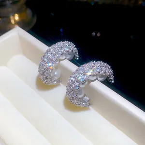 Makroaufnahme von französischen C-Ohrringen mit Zirkonia und eleganten Perlen