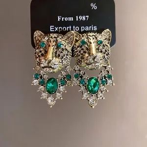 Vintage style gold leopard earrings with green emerald and sparkling diamond accents