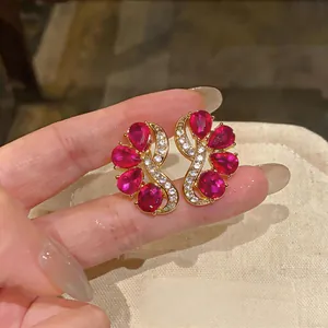 Detailed macro view showing the exquisite red pear-shaped and oval gem stud earrings.