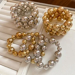 Close-up of gold and silver metallic chunky beaded bracelets in a jewelry tray