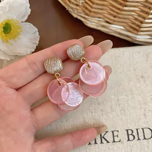 Detailed macro view of pink layered cat eye stone drop earrings with gold wire wrap