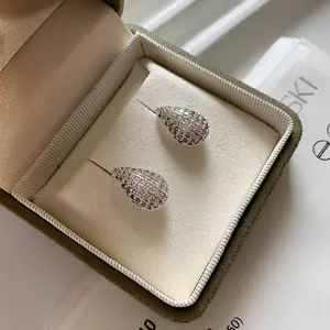 Primo piano di orecchini a goccia in zirconia cubica in un portagioie in velluto verde