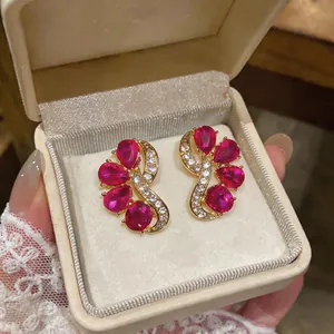 Detailed view of elegant magenta waterdrop crystal stud earrings in a luxury box