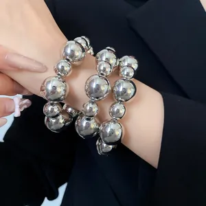 Macro view of metallic silver chunky bead bracelets with reflective smooth finish