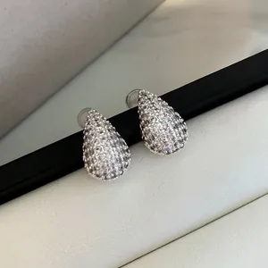 Dettaglio ravvicinato di orecchini a lobo a goccia in zirconi cubici argento brillanti