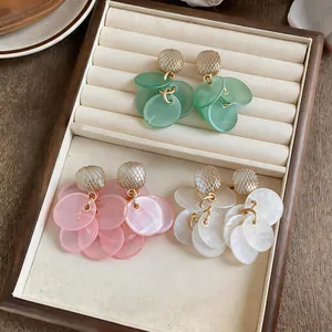 Close-up detail of colorful cat's eye stone tassel earrings set in a jewelry box