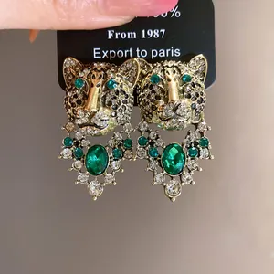Macro detail of vintage leopard head earrings with green crystals and rhinestones