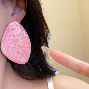 Dettaglio orecchino a perno rosa marmorizzato, forma geometrica irregolare grande