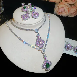 Gros plan d'un ensemble de bijoux floraux en zircon avec pierres roses et vertes