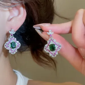 Détail rapproché de boucles d'oreilles en zircon vert émeraude de style palais vintage chic