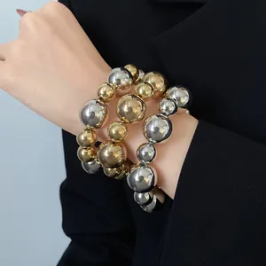 Detail view of 3pcs metallic beaded bracelets in gold and silver finish on model
