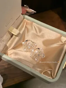 Detailed macro shot showing elegant floral basket earrings inside a premium gift box