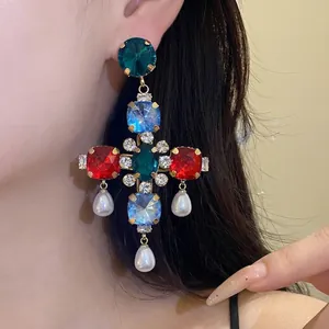 Auffällige bunte Edelstein-Kreuzohrringe mit eleganten Tropfenperlen an einem Model