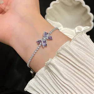 Close-up of elegant purple bow zircon bracelet with 18k gold plating on wrist
