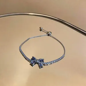 Detailed view of an elegant 18k gold plated bracelet featuring a blue zircon bow.